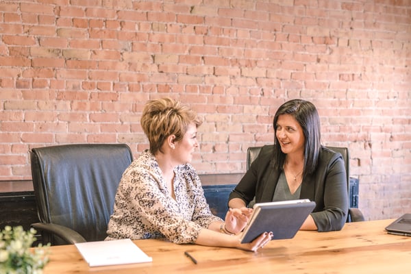 Two women talking in a work setting