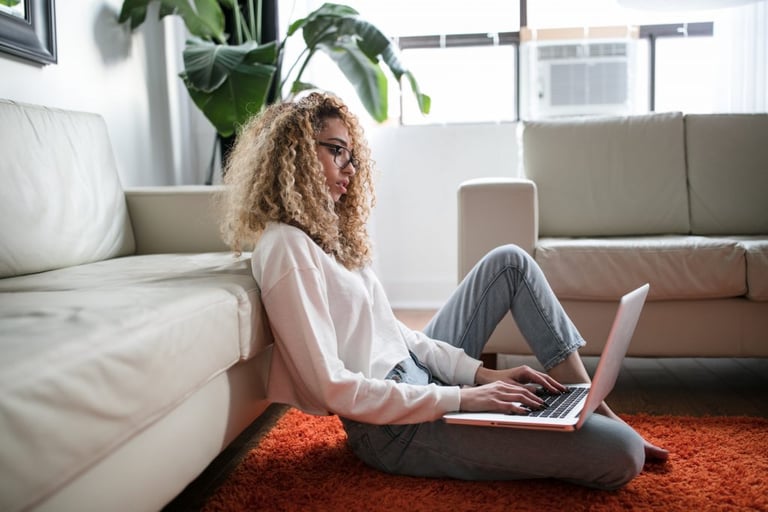 Woman working on computer at home; image by Thought Catalog for Unsplash